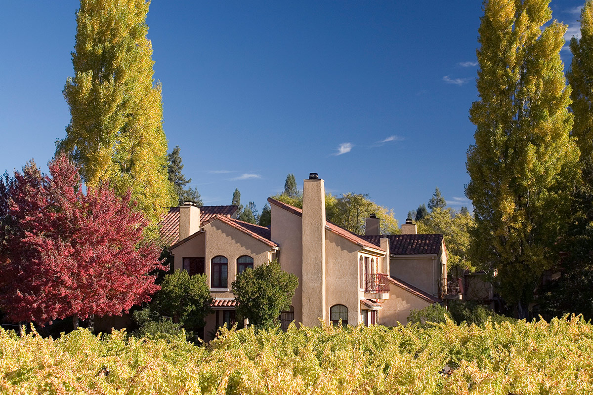 Surrounded by lush trees and gardens, exterior of the initimate two-story buildings at Vintners Resort in Sonoma wine country.