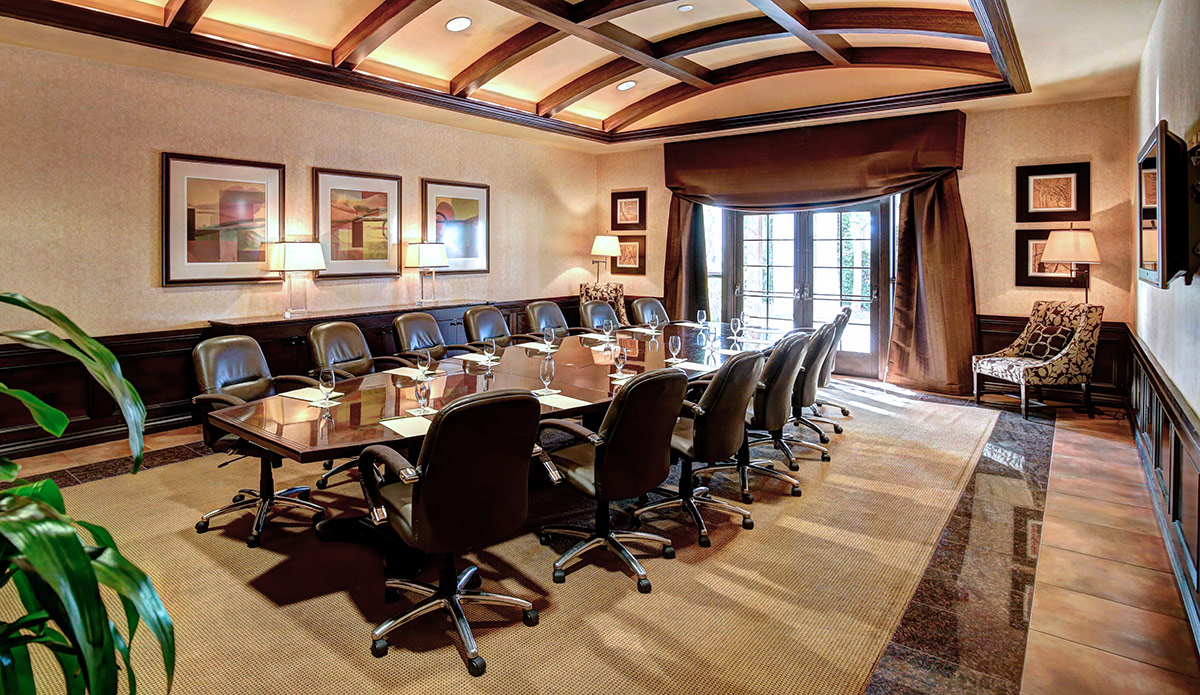 The Executive Boardroom at Vintners Resort, featuring a large boardroom table with comfortable leather chairs around it, and opens to a terrace.