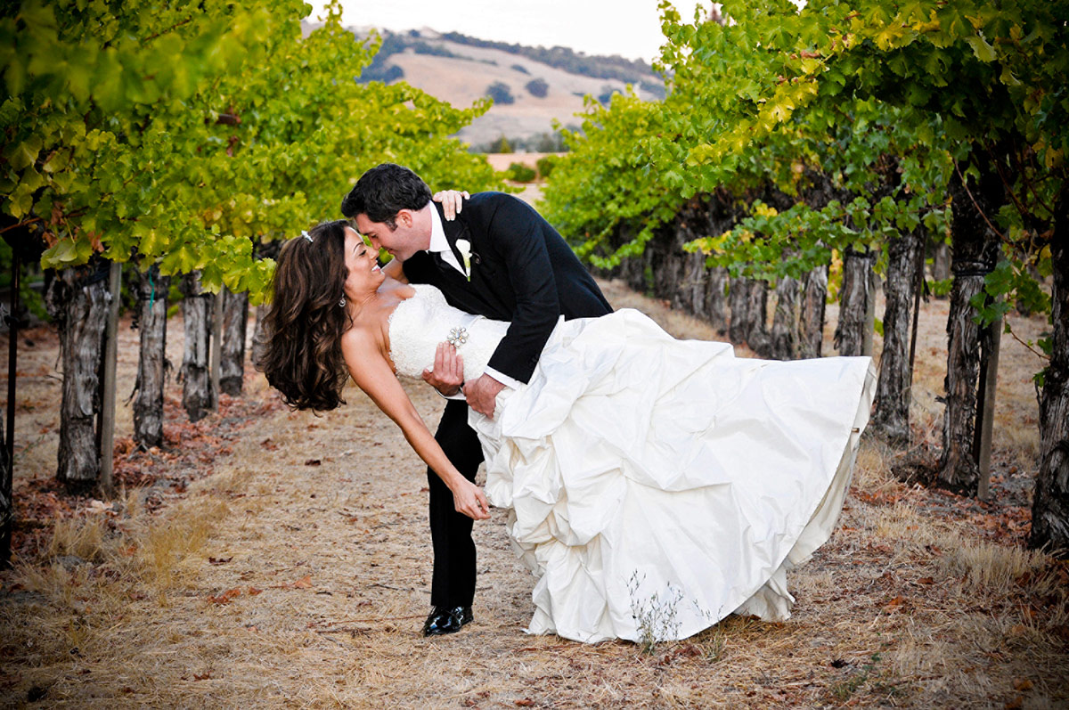 With Vintners Resort's working vineyard as the backdrop, a wedding couple poses for their special day.