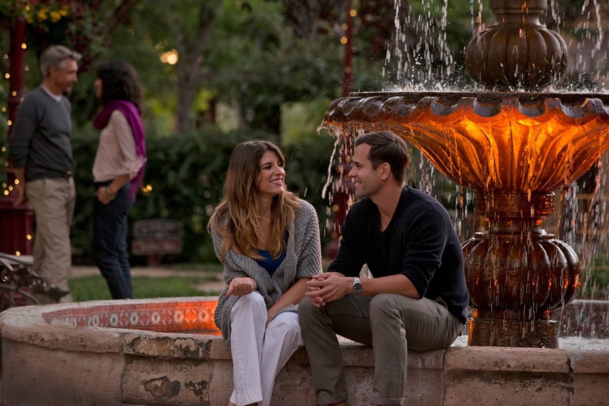 Two couples gather by the fountain in Vintners Resort's garden courtyard.