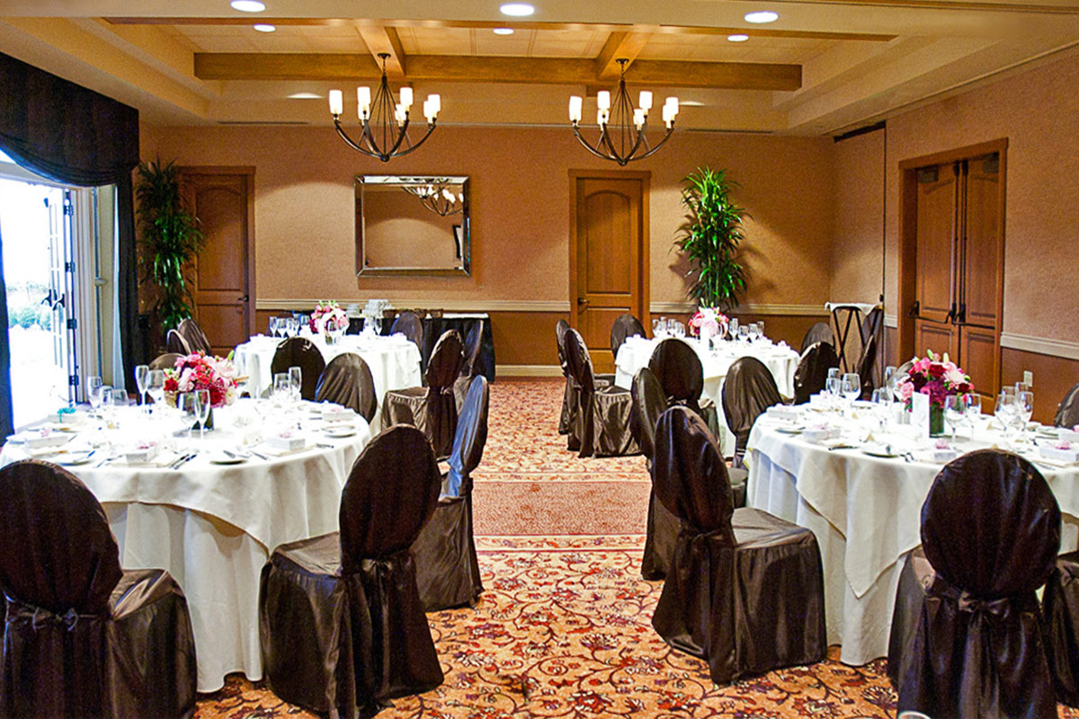 Banquet setting with table rounds and chairs with covers in the Cypress Ballroom at Vintners Resort.