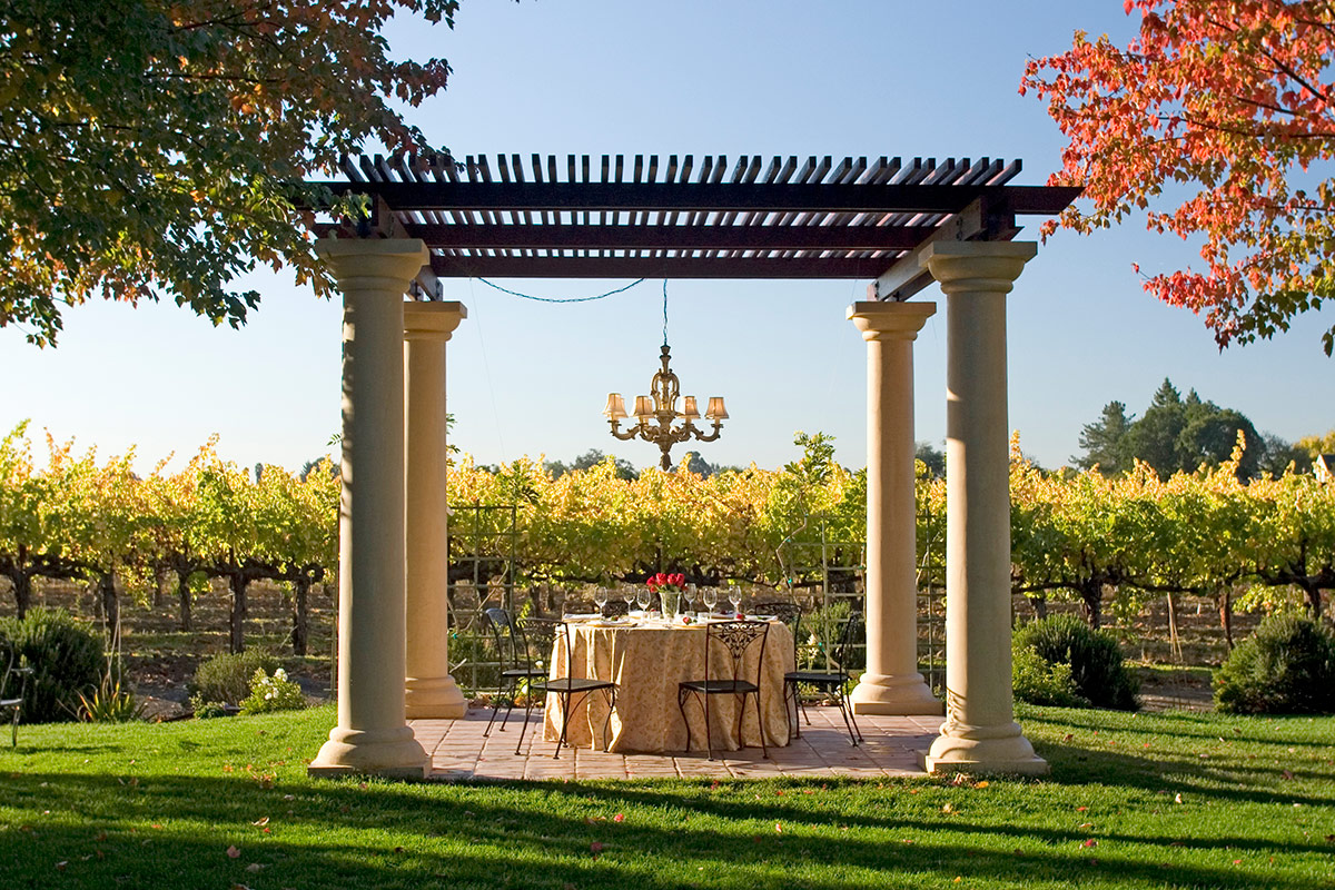 A round dining table set under the chandelier of the Fontana Pavilion for an intimate dinner.
