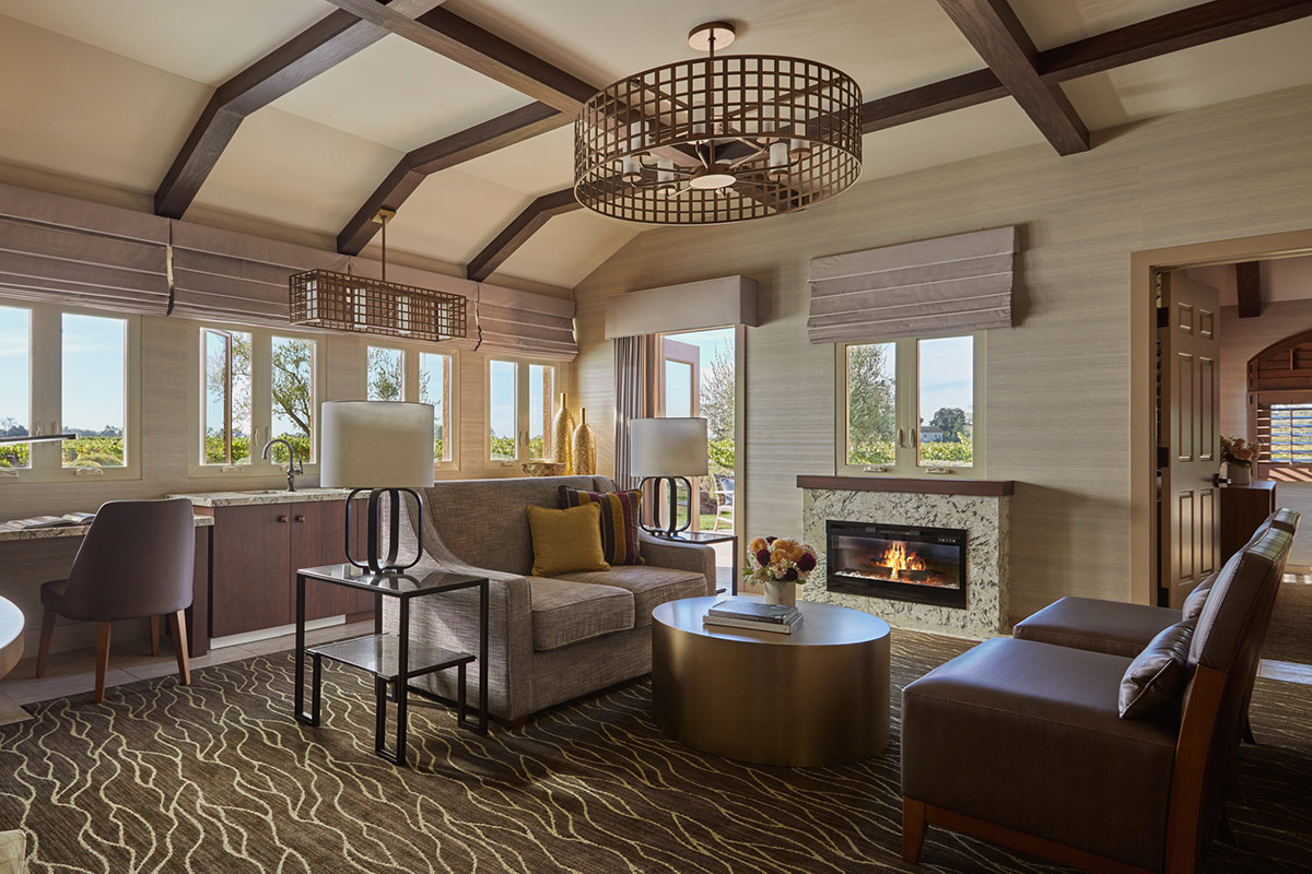 The spacious living room of the Vineyard Terrace Deluxe Suite at Vintners Resort, features a fireplace, a wet bar, and opens to an outdoor terraace.