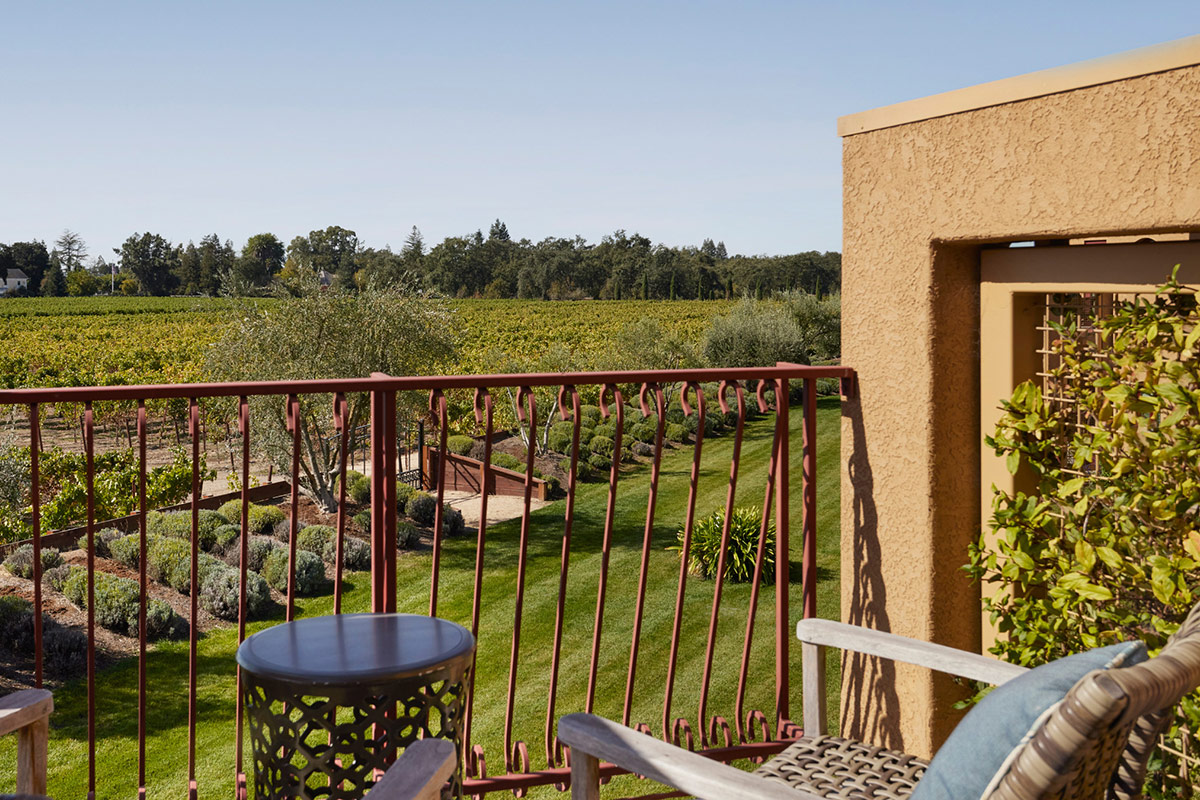 A furnished balcony on the upper floor of Vintners Resort's guest accommodations, overlooking the lavender fields and vineyards beyond.