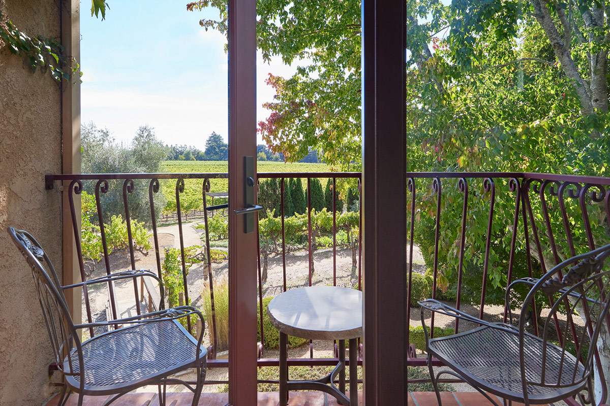 Furnished balcony on the second floor of Vintners Resort's guest accommodations, overlooks meticulous gardens and the vineyard.