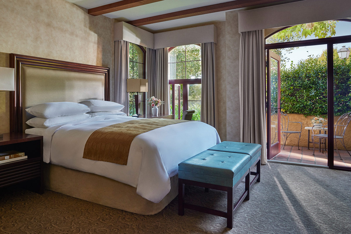 A giant feather California King bed in the Courtyard King Room. Windows open to view of the lovely garden courtyard.